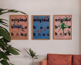 May include: Three framed posters with the text "original bauhaus" in black letters on a light pink, light blue, and light green background. The posters feature black and white silhouettes of people in various poses.
