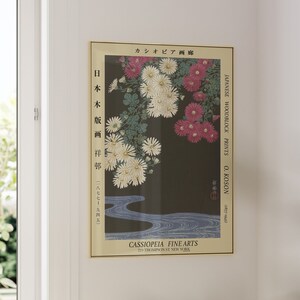 May include: A vintage Japanese woodblock print by O. Koson, featuring a floral design of white and pink chrysanthemums against a dark background. The print is titled "Japanese Woodblock Prints" and includes the artist's name and dates. The print is framed and has a gold border.