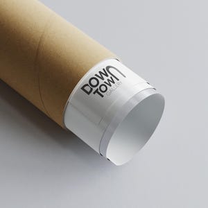 May include: A close-up of a brown cardboard tube with a white label that says "Downtown Gallery".