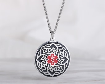 May include: A silver medical alert pendant necklace. The round pendant has a black Celtic knot design with a red medical symbol. The necklace has a fine chain.