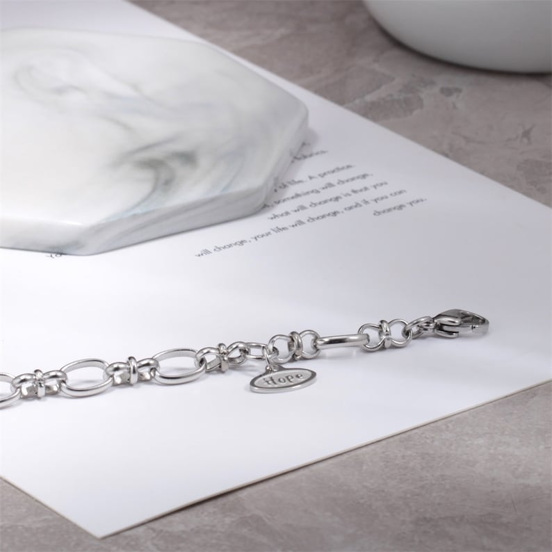 May include: A silver chain bracelet with a charm that says "Hope".