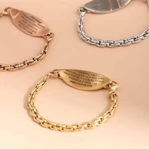 May include: Three medical alert bracelets featuring a textured chain link band and an oval-shaped metal identification plate. One bracelet is gold-toned, one is rose gold-toned, and one is silver-toned, each engraved with personal medical information.