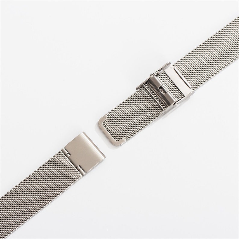 May include: A silver metal watch band with a clasp. The band is made of a fine mesh material.