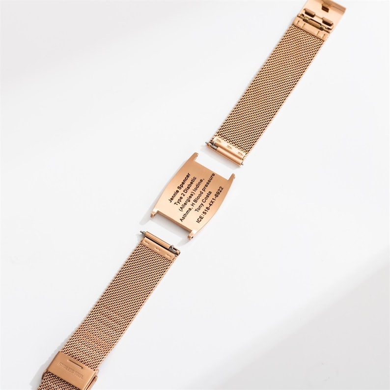 May include: A gold metal bracelet with a removable medical alert tag. The tag is engraved with the text "Jennie Spencer, Type 2 Diabetic (Allergies) Iodine, Asthma, H Blood Pressure, Tony Costa, ICE: 518-4X1-6922".