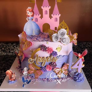 May include: A custom-decorated birthday cake featuring a princess theme. The cake is adorned with a pink castle, a princess figurine, butterflies, and floral decorations. The name "Angela" is displayed in gold script, with the number "4" indicating the birthday age.