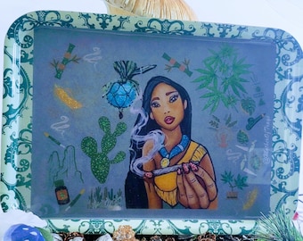 May include: A rectangular metal rolling tray featuring a central illustration of a person with long dark hair holding a smoking item. The tray has a green ornate border and includes various botanical and desert-themed graphics surrounding the figure.