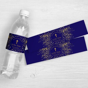 Puede incluir: Una botella de agua transparente con una etiqueta azul marino y dos etiquetas adicionales. Las etiquetas presentan texto y detalles dorados, con las palabras "Primera Comunión", "Dios bendiga [Nombre]" y "Holy Cross Chapel".