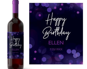 Może przedstawiać: Butelka wina z fioletową zakrętką i etykietą z napisem "Happy Birthday ELLEN 7/25/19XX" białym skryptem. Etykieta ma ciemnoniebieskie tło z fioletowymi kropkami bokeh. Butelka jest wypełniona czerwonym winem.