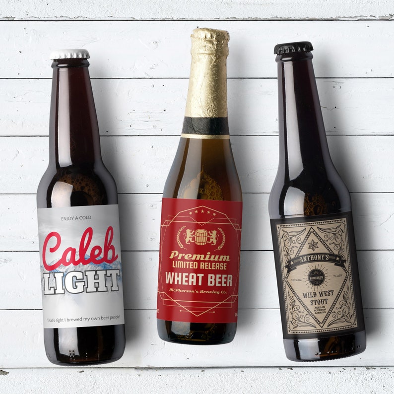 May include: Three brown glass beer bottles with different labels. The first bottle has a white label with the text "ENJOY A COLD Caleb LIGHT" and the text "That's right I brewed my own beer people". The second bottle has a red label with the text "Premium Limited Release Wheat Beer McPherson's Brewing Co.". The third bottle has a tan label with the text "ANTHONY'S WILD WEST STOUT".
