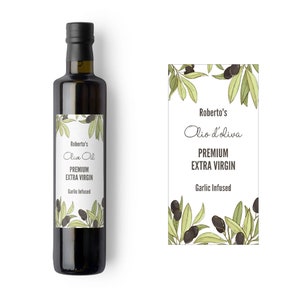 Puede incluir: Una botella de vidrio de aceite de oliva Roberto's, Extra Virgen Premium, con infusión de ajo. La botella tiene una etiqueta negra con un diseño de rama de olivo verde.