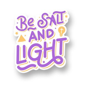 Puede incluir: Una pegatina con las palabras "Be Salt AND Light" en morado, delineadas en amarillo. El diseño incluye una bombilla con una cruz, estrellas y un triángulo. La pegatina tiene un borde blanco y está sobre un fondo blanco.