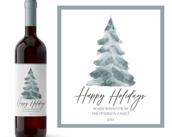 May include: A wine bottle label with a watercolor illustration of a blue-grey Christmas tree. The text reads "Happy Holidays" with the words "Warm Wishes from The Peterson Family 20XX" below.