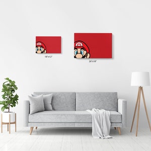 Może przedstawiać: Czerwony wydruk na pł&oacute;tnie przedstawiający zbliżenie twarzy Super Mario. Wydruk dostępny jest w dw&oacute;ch rozmiarach: 46x30 cm i 66x46 cm.