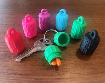 Pequeño frasco para pastillas, ideal para llavero o collar, con tapa de rosca y fácil agarre.