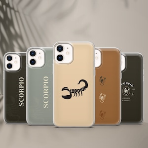 May include: Five clear phone cases with different designs featuring the zodiac sign Scorpio. The cases are all clear and show the phone's camera lens. The designs include a scorpion silhouette, the word "Scorpio" in a script font, and a scorpion with the words "Strength & Serenity".