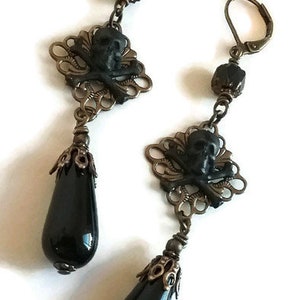 CAUSA MORTIS Boucles d&#39;oreilles gothiques en laiton filigrane tête de mort en verre noir