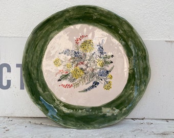 Handmade ceramic plate. Hand painted with flower ornaments. Artistic vintage style.