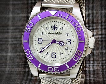 May include: A silver wristwatch with a purple bezel and a silver mesh band. The watch face is silver with black numerals and hands. The watch is marked "Roman Miller".