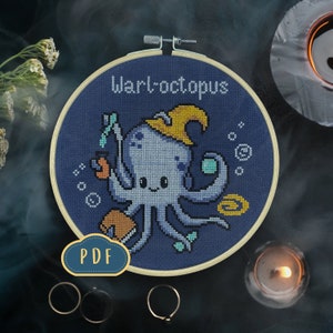 Puede incluir: Un patrón de punto de cruz con un lindo pulpo de dibujos animados que lleva un sombrero de bruja y sostiene una botella de poción. El patrón se titula "Warlocktopus" y está disponible para descargar en PDF.