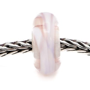 Puede incluir: Una cuenta de vidrio de forma cilíndrica, con una mezcla de remolinos blancos, rosa claro y lavanda. La cuenta está ensartada en una cadena plateada, creando una paleta de colores suaves y pastel. El diseño de la cuenta recuerda al mármol.