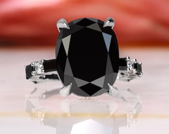 May include: A black diamond engagement ring with a silver band and small diamonds on the sides.
