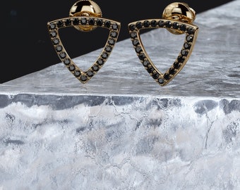 May include: A pair of gold earrings with a triangular shape. The earrings are set with black diamonds.