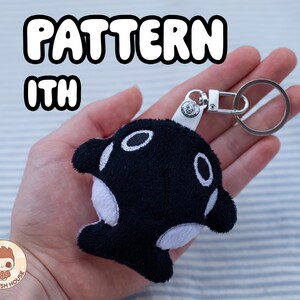 May include: A black and white orca plush keyring with a silver ring. The keychain features the text "PATTERN ITH" in a bubble font. The Plush House logo is in the bottom left corner.