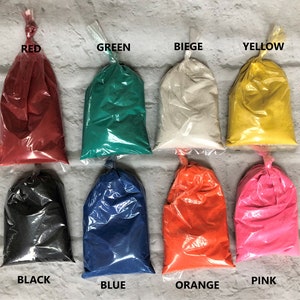 May include: Ten small plastic bags filled with different colored sand. The bags are labeled with the colors: red, green, beige, yellow, black, blue, orange, and pink.
