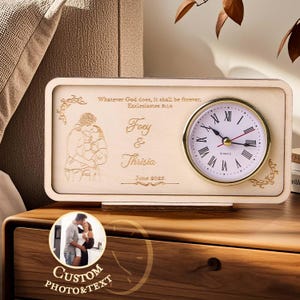May include: A wooden clock with a gold-rimmed clock face and Roman numerals. The clock features a personalized design with the names "Foey & Thrisia" and the date "June 2025". The text "Whatever God does, it shall be forever" is also engraved.