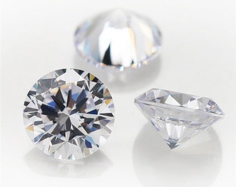 May include: Three clear round diamonds of varying sizes on a white background.