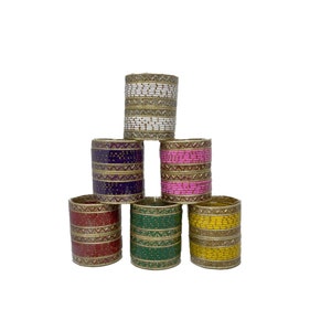 May include: Set of six colorful bangles with gold accents. The bangles are stacked in a pyramid shape and feature different patterns and designs.
