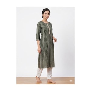 May include: A long olive green tunic with a geometric pattern and three-quarter sleeves. The tunic has a decorative embroidered neckline and is paired with white pants. The outfit is suitable for casual or semi-formal wear.