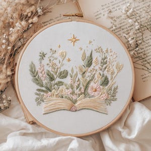Floral Book Embroidery Pattern featuring an open book surrounded by delicate pastel flowers and soft glowing stars. This dreamy and cozy design is perfect for book lovers, reading corner decor, and those who enjoy peaceful, aesthetic embroidery projects. Ideal as a handmade gift for literary fans or anyone who loves gentle, pastel artwork. Includes 6 hoop sizes and easy instructions for all skill levels.