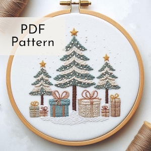 May include: Embroidered Christmas tree and gift pattern in a wooden hoop. The design features three detailed Christmas trees with star toppers, snow, and wrapped gifts in various colours. The text "PDF Pattern" is visible.