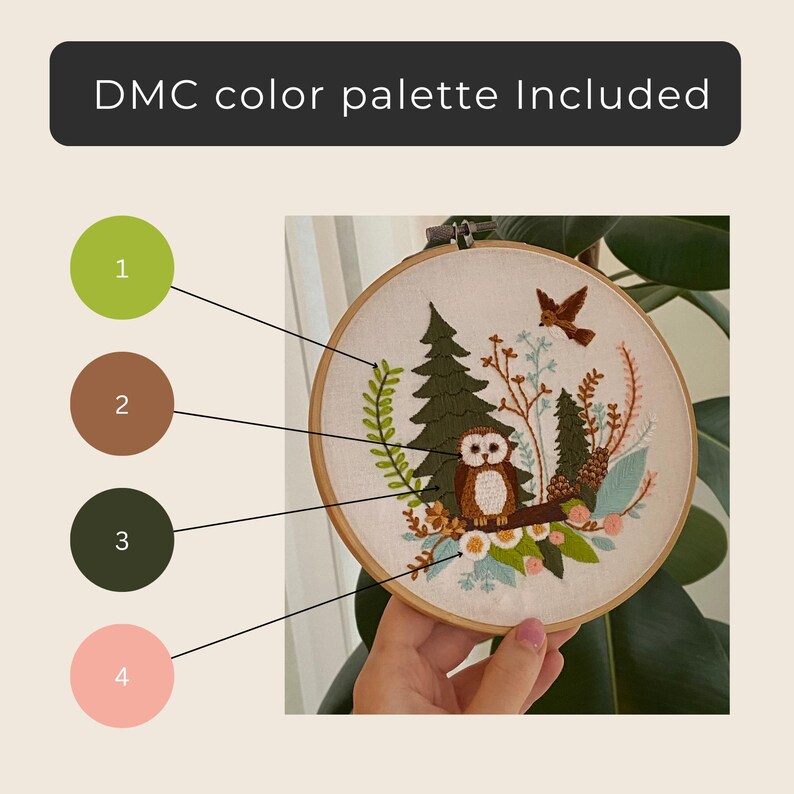 May include: An embroidery hoop featuring a woodland scene with an owl, trees, and a bird. The design includes a DMC color palette. The hoop is held by a hand.