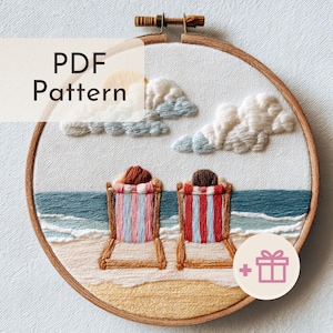 May include: Embroidered beach scene in a wooden hoop. The artwork features two beach chairs with striped fabric, a sandy beach, blue ocean, fluffy clouds, and a sun. Text reads "PDF Pattern".