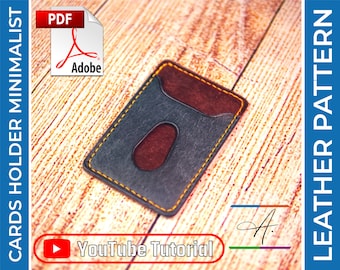 May include: A black leather card holder with a brown suede pocket and yellow stitching. The card holder is on a wooden surface. The text "YouTube Tutorial" is visible in the image.