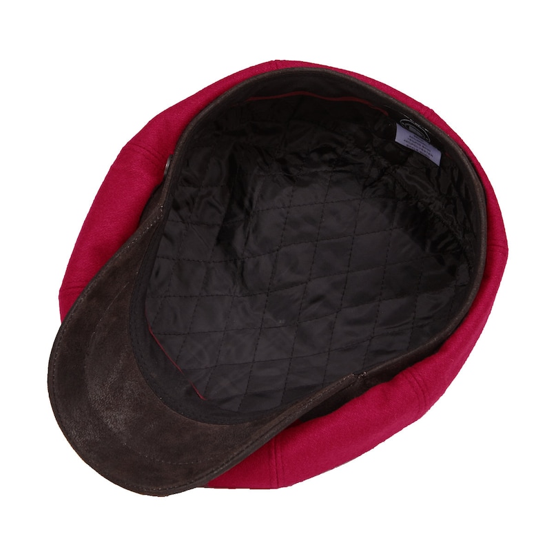 May include: A red wool newsboy cap with a brown suede brim. The cap has a quilted lining.