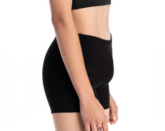 May include: A black sleeveless crop top and black shorts. The top has a V-neckline.