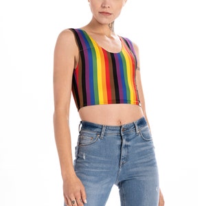 May include: A cropped tank top with vertical rainbow stripes. The tank top is sleeveless and has a scoop neck.