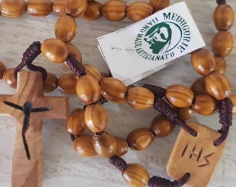 Può includere: Un rosario di legno con perline marroni e un crocifisso di legno. Il crocifisso presenta un'immagine scolpita di Gesù Cristo. Il rosario è realizzato a Medjugorje, una città della Bosnia ed Erzegovina, nota per la sua importanza religiosa.