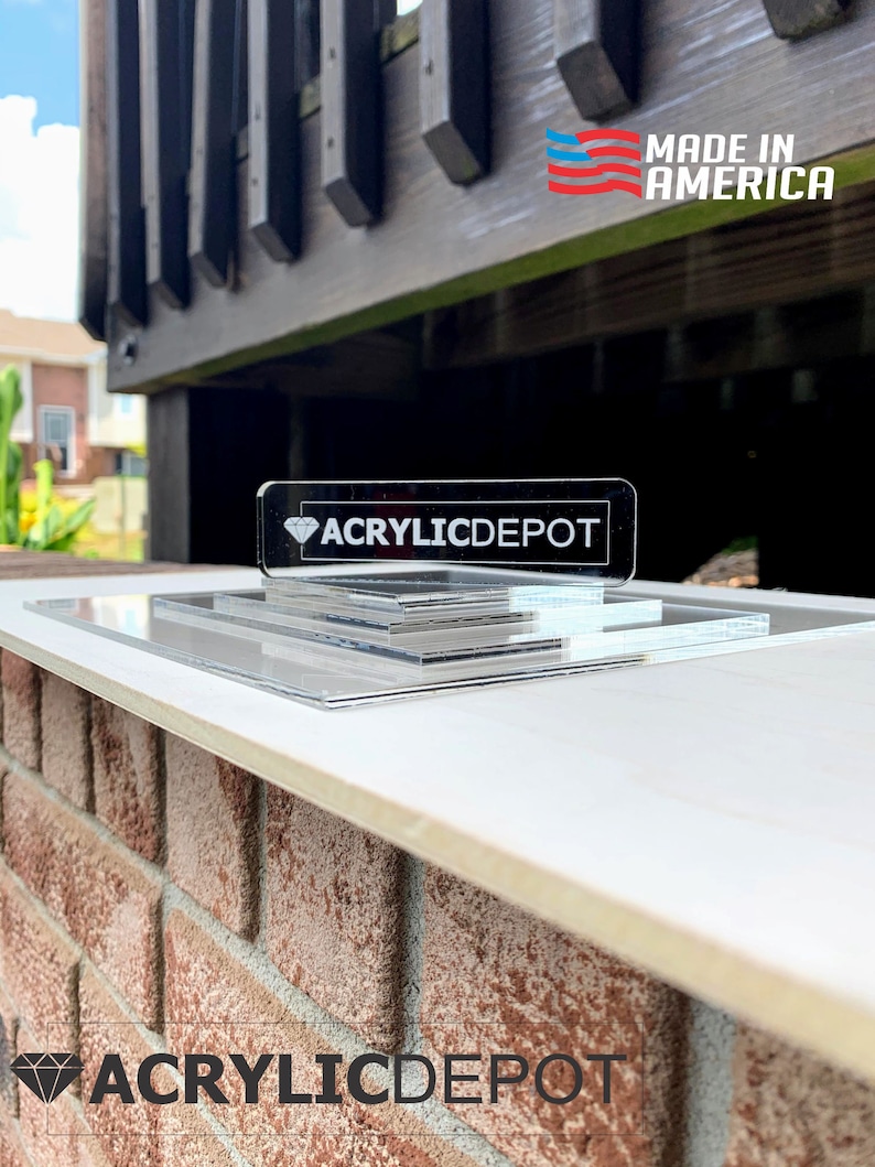 May include: A clear acrylic display stand with three tiers. The stand is made in the USA and features the logo "ACRYLICDEPOT" on the top tier.