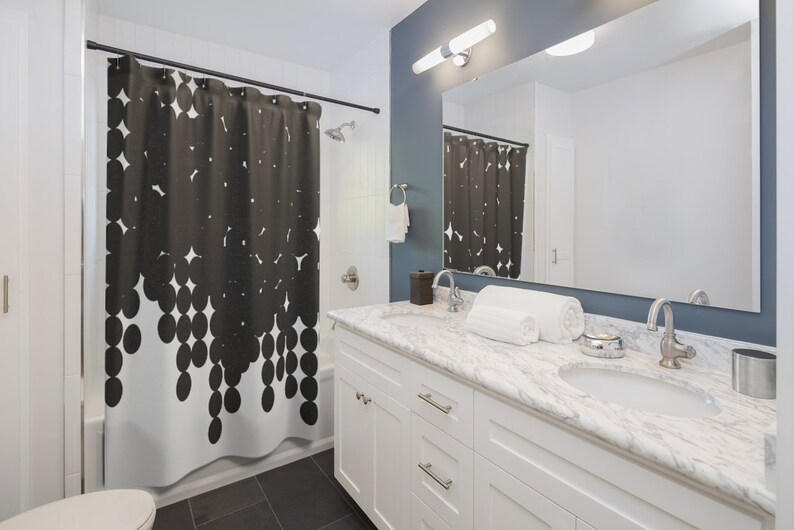 Puede incluir: Un ba&ntilde;o blanco con una cortina de ducha en blanco y negro con un patr&oacute;n de c&iacute;rculos. El ba&ntilde;o tiene un tocador blanco con una encimera de m&aacute;rmol y dos lavabos. Hay una toalla en la encimera.