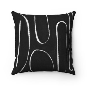 May include: Black and white throw pillow with a geometric pattern of white lines on a black background.