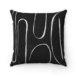 May include: Black and white throw pillow with a geometric pattern of abstract lines.