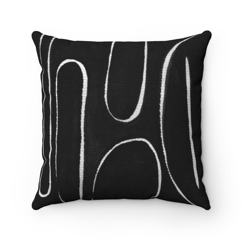 May include: Black and white throw pillow with a geometric pattern of abstract lines.