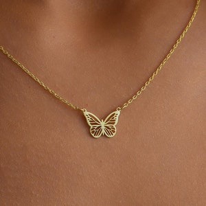 Peut inclure: Un collier en chaîne dorée avec un pendentif délicat en forme de papillon.