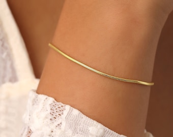May include: A delicate gold chain bracelet with a snake chain design.