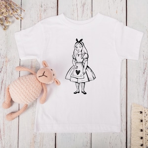 May include: White baby t-shirt with a black and white illustration of Alice in Wonderland holding a playing card with a heart on it.