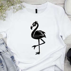 May include: A white t-shirt with a black silhouette of a flamingo standing on one leg.